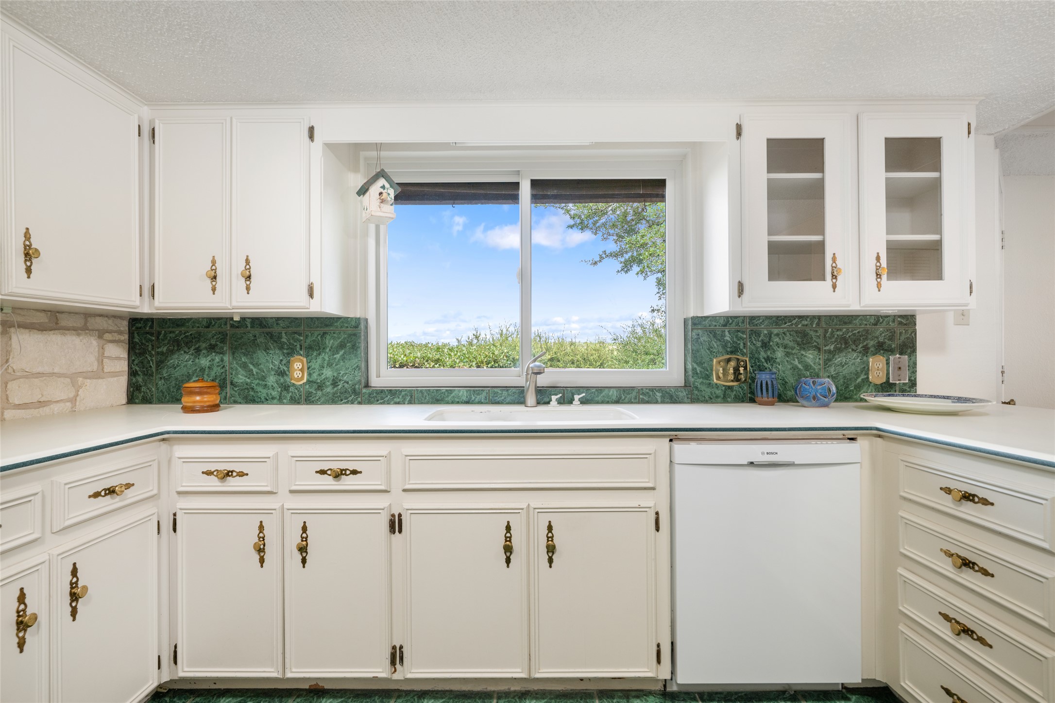 5319 Musket Ridge Austin, TX 78759 - Photo 13 of 39 A well-lit kitchen with classic white cabinetry and a view of verdant landscaping through a large window.