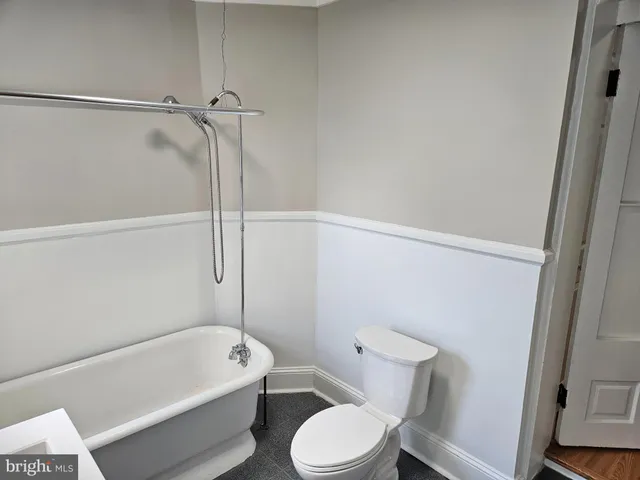 a white toilet sitting next to a bath tub