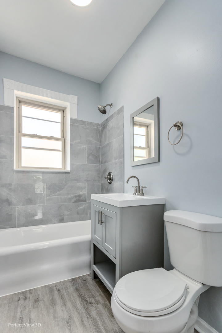 2212 East 70th Street, Unit 3D Chicago, IL 60649 - Photo 17 of 21 a white toilet sitting next to a bathroom sink