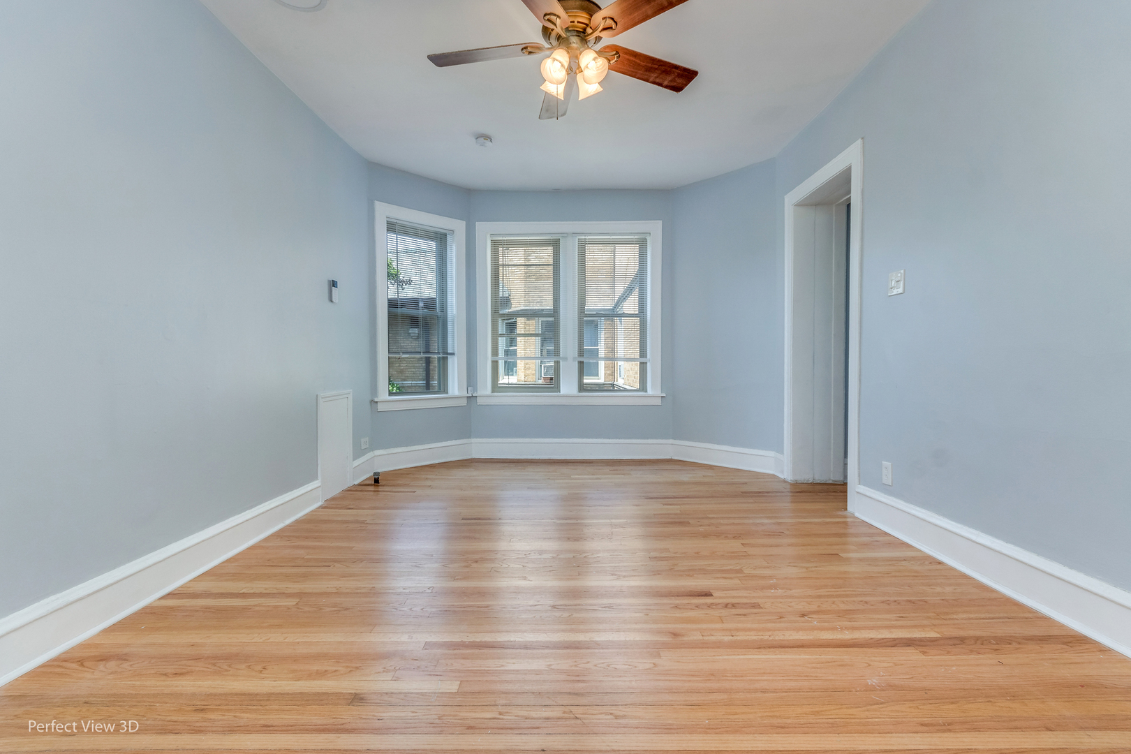 2212 East 70th Street, Unit 3D Chicago, IL 60649 - Photo 8 of 21 a view of an empty room with wooden floor and a window