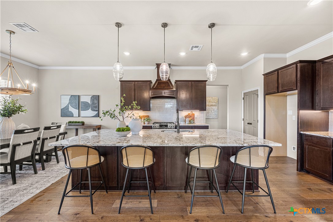 2136 Oak Draw Court Belton, TX 76513 - Photo 10 of 46 a kitchen with stainless steel appliances kitchen island granite countertop a dining table chairs and refrigerator