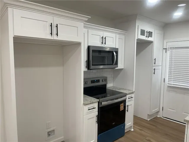 a kitchen with a stove microwave and sink