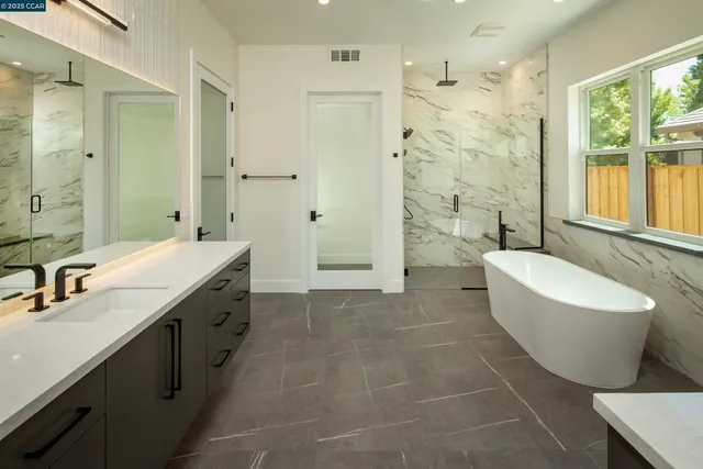 a spacious bathroom with a double vanity sink mirror and a bathtub