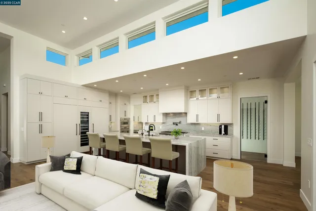 a living room with stainless steel appliances kitchen island granite countertop a couch and cabinets