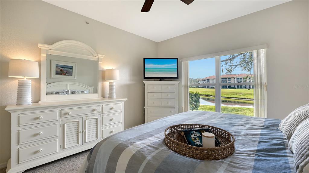 6556 Fairway Gardens Drive Bradenton, FL 34203 - Photo 13 of 43 a bedroom with a bed and ceiling fan