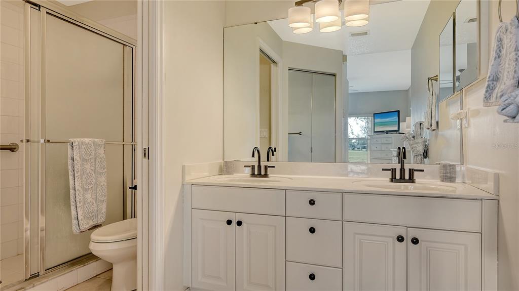6556 Fairway Gardens Drive Bradenton, FL 34203 - Photo 16 of 43 a bathroom with a double vanity sink toilet and shower