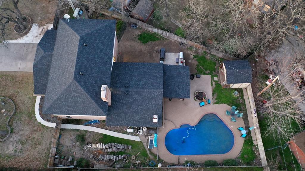 an aerial view of a house with backyard space and swimming pool