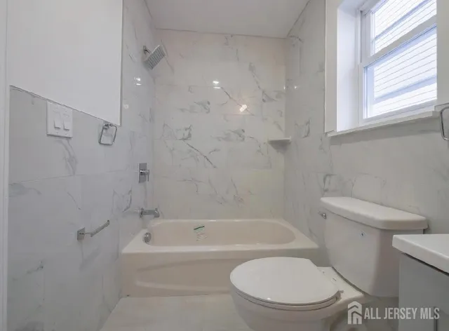 a bathroom with a toilet and a bath tub