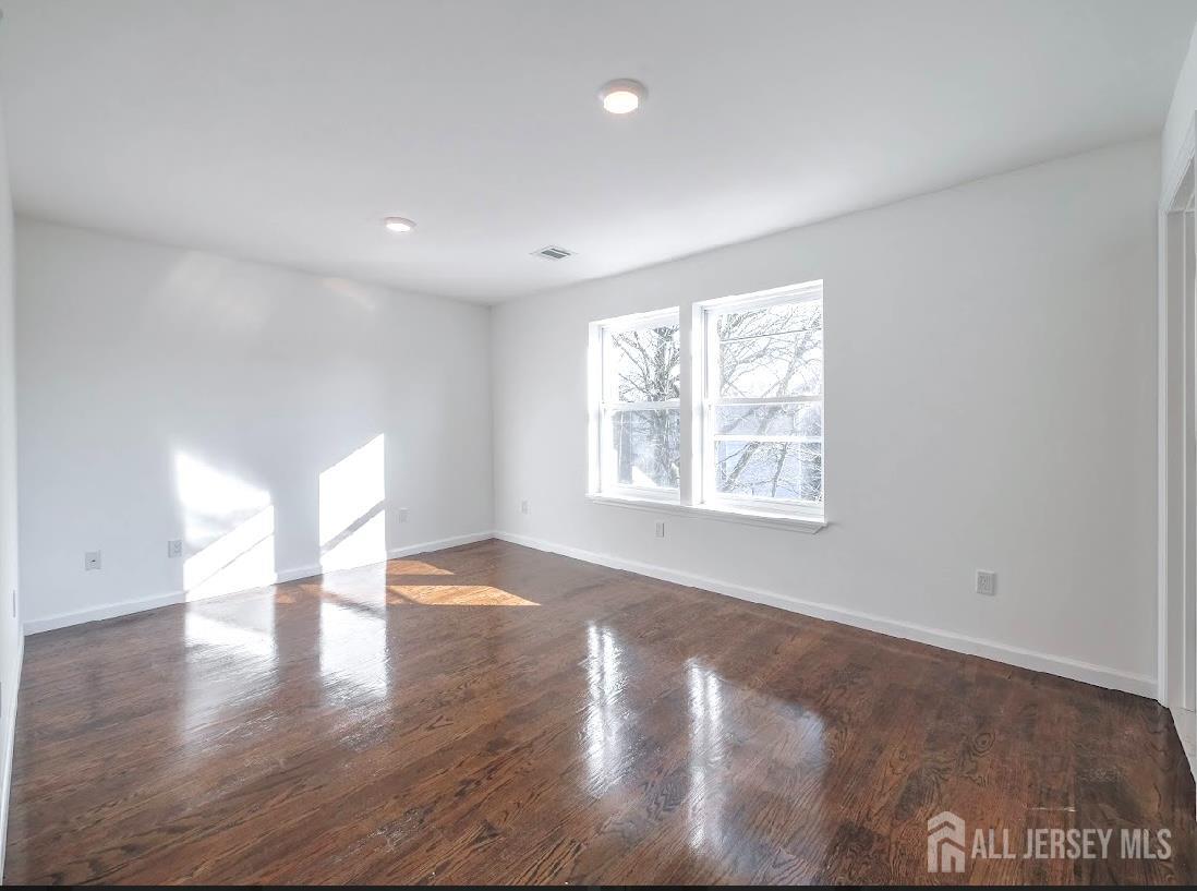 496 South 18th Street, Unit 2 Newark, NJ 07103 - Photo 13 of 15 a view of an empty room with wooden floor and a window