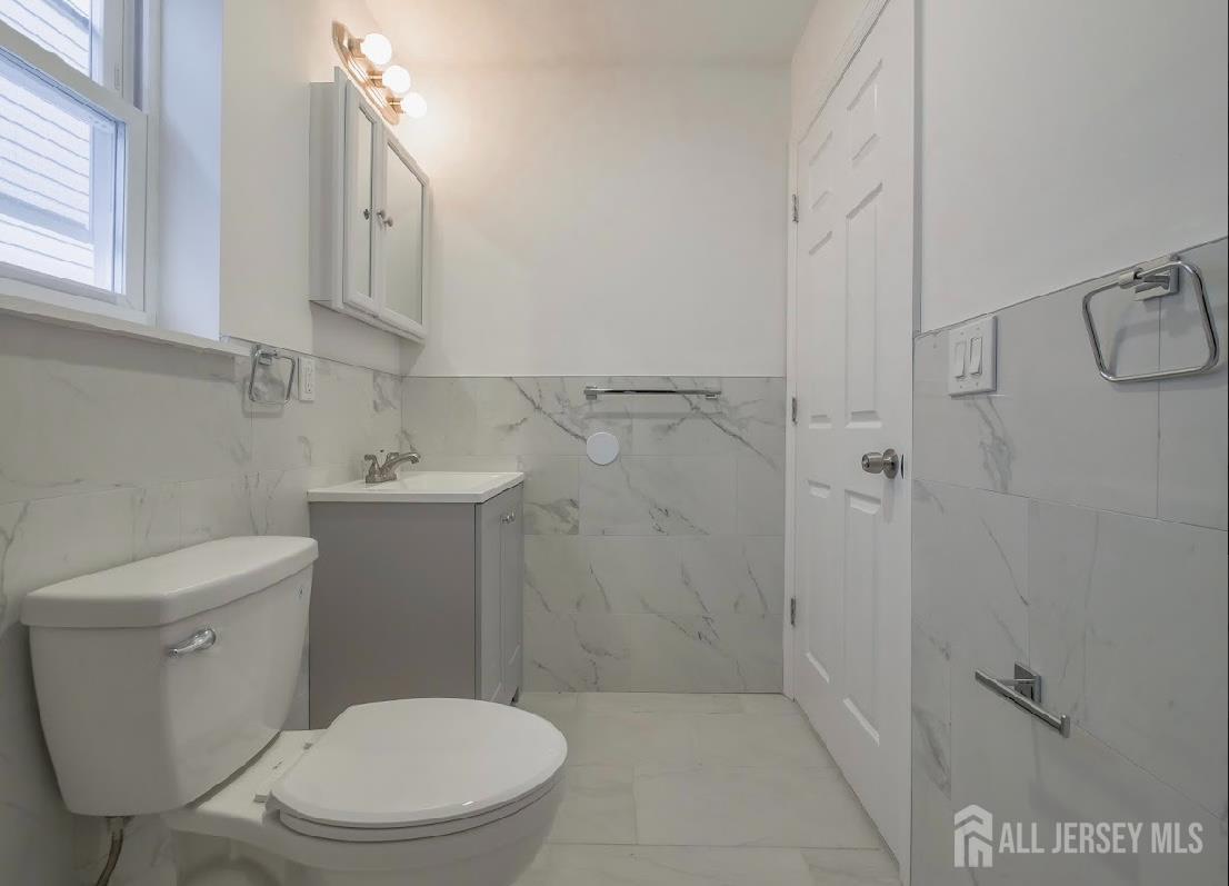 496 South 18th Street, Unit 2 Newark, NJ 07103 - Photo 14 of 15 a white toilet sitting next to a bathroom sink
