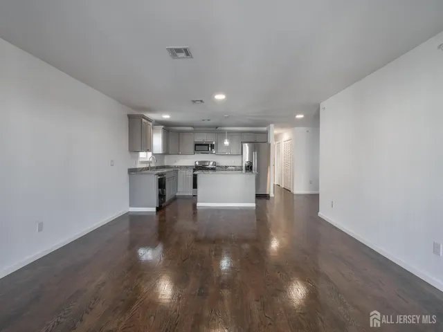 a view of a kitchen with cabinets and wooden floor