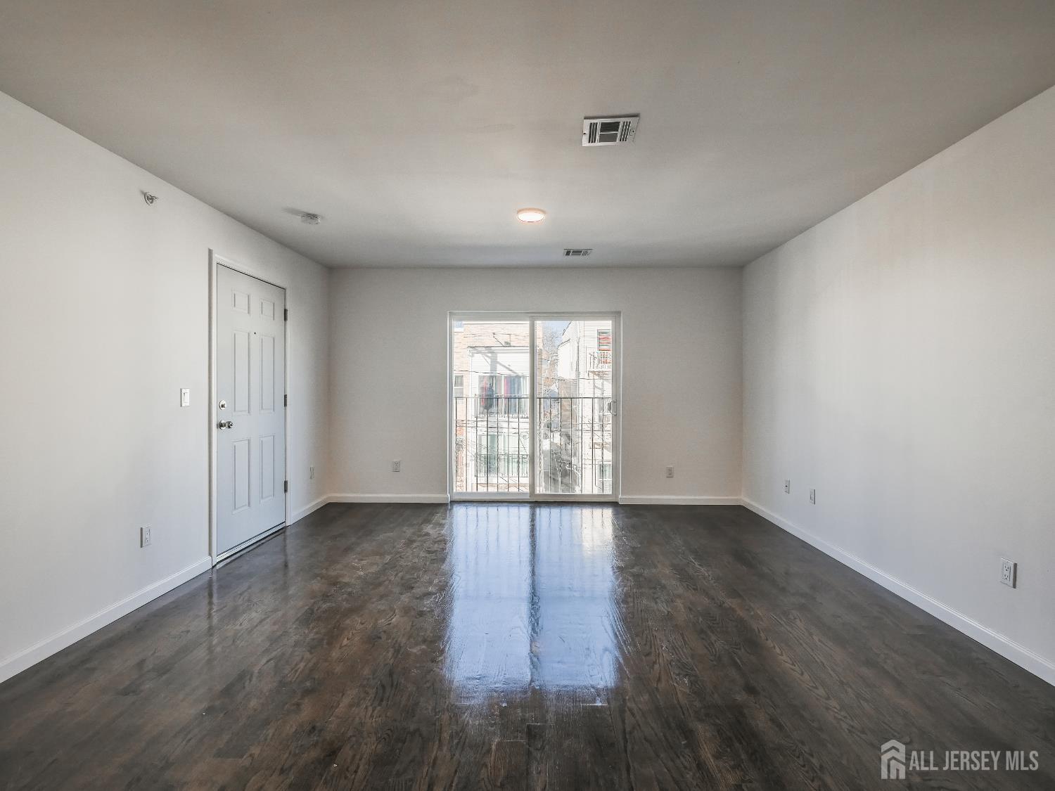 496 South 18th Street, Unit 2 Newark, NJ 07103 - Photo 5 of 15 wooden floor in an empty room with a window