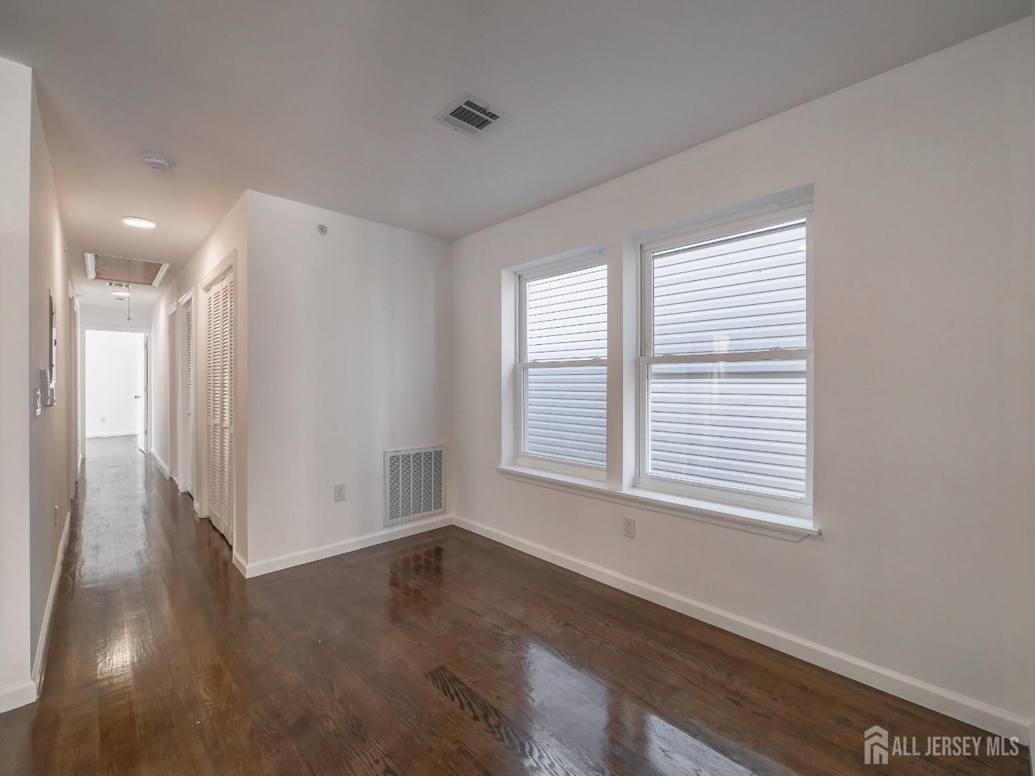 496 South 18th Street, Unit 2 Newark, NJ 07103 - Photo 6 of 15 a view of an empty room with wooden floor and a window