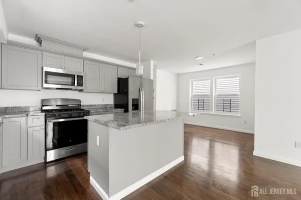 a kitchen with stainless steel appliances kitchen island granite countertop a stove a sink and a refrigerator