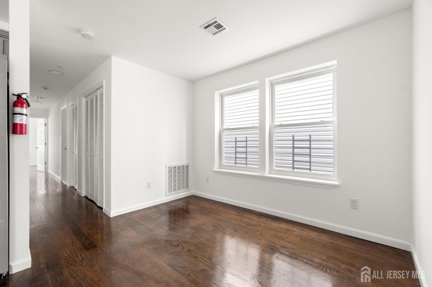 496 South 18th Street, Unit 2 Newark, NJ 07103 - Photo 8 of 21 a view of an empty room with wooden floor and a window