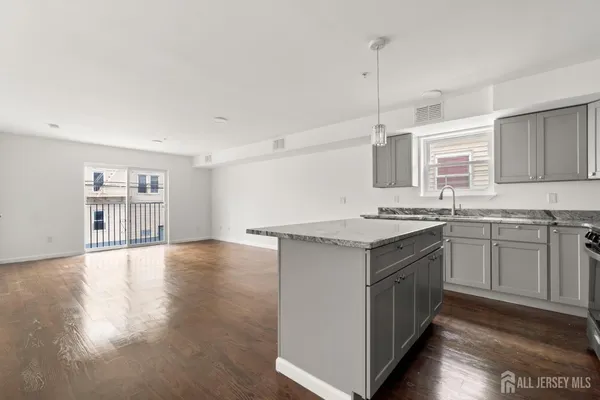a kitchen with granite countertop a sink and cabinets