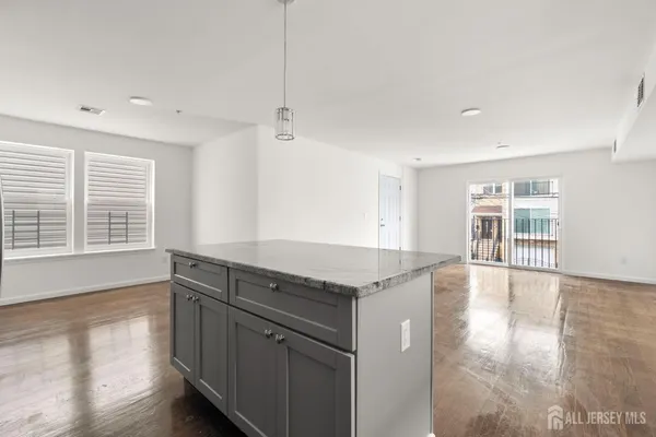 a open kitchen with granite countertop a stove and a wooden floors