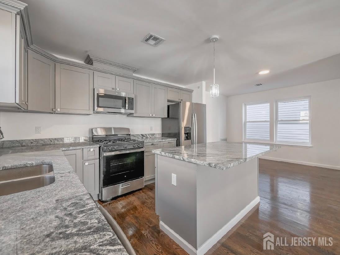 496 South 18th Street, Unit 2 Newark, NJ 07103 - Photo 10 of 15 a kitchen with kitchen island granite countertop a stove sink and cabinets