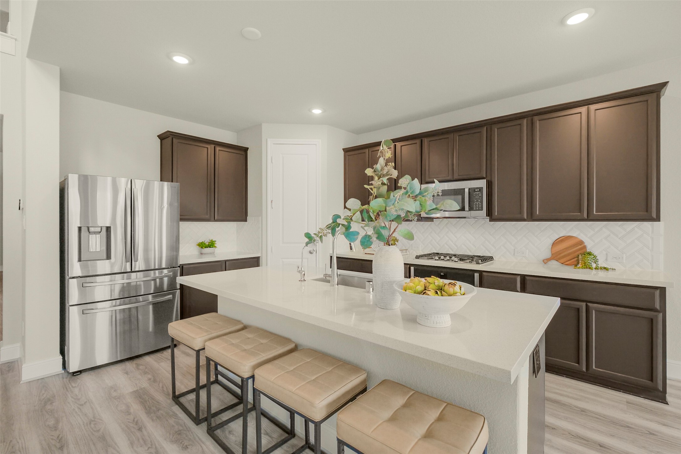 10514 Rigel Rdg Way Richmond, TX 77406 - Photo 19 of 50 The kitchen is built around a huge quartz island with seating for four, offering plenty of prep space while keeping everyone connected to the main living area.