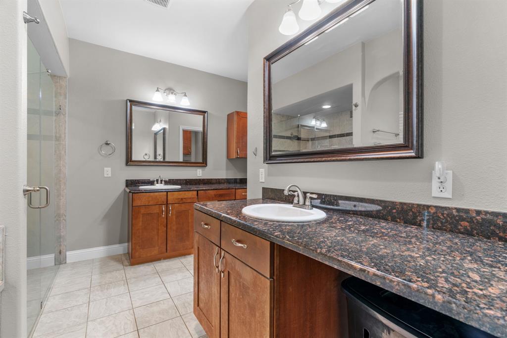 217 Naibara Trail Weatherford, TX 76088 - Photo 14 of 35 a bathroom with a granite countertop sink and a mirror