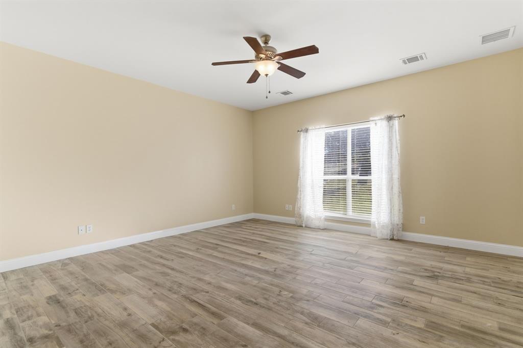 217 Naibara Trail Weatherford, TX 76088 - Photo 21 of 40 an empty room with wooden floor and ceiling fan