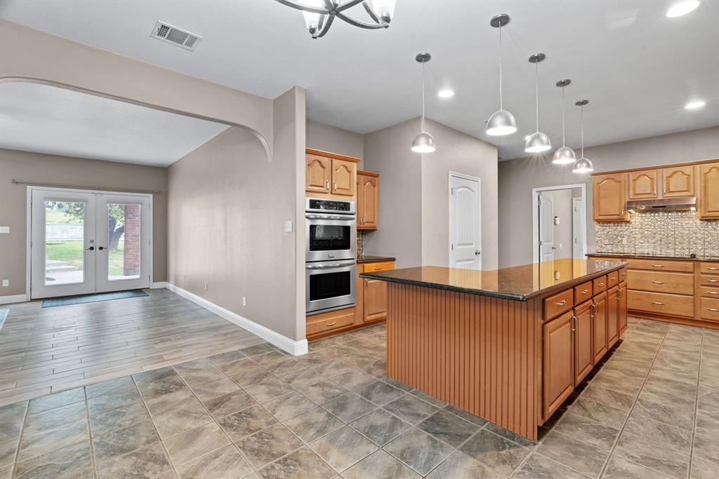 217 Naibara Trail Weatherford, TX 76088 - Photo 10 of 40 a view of a kitchen with kitchen island granite countertop a refrigerator and a stove