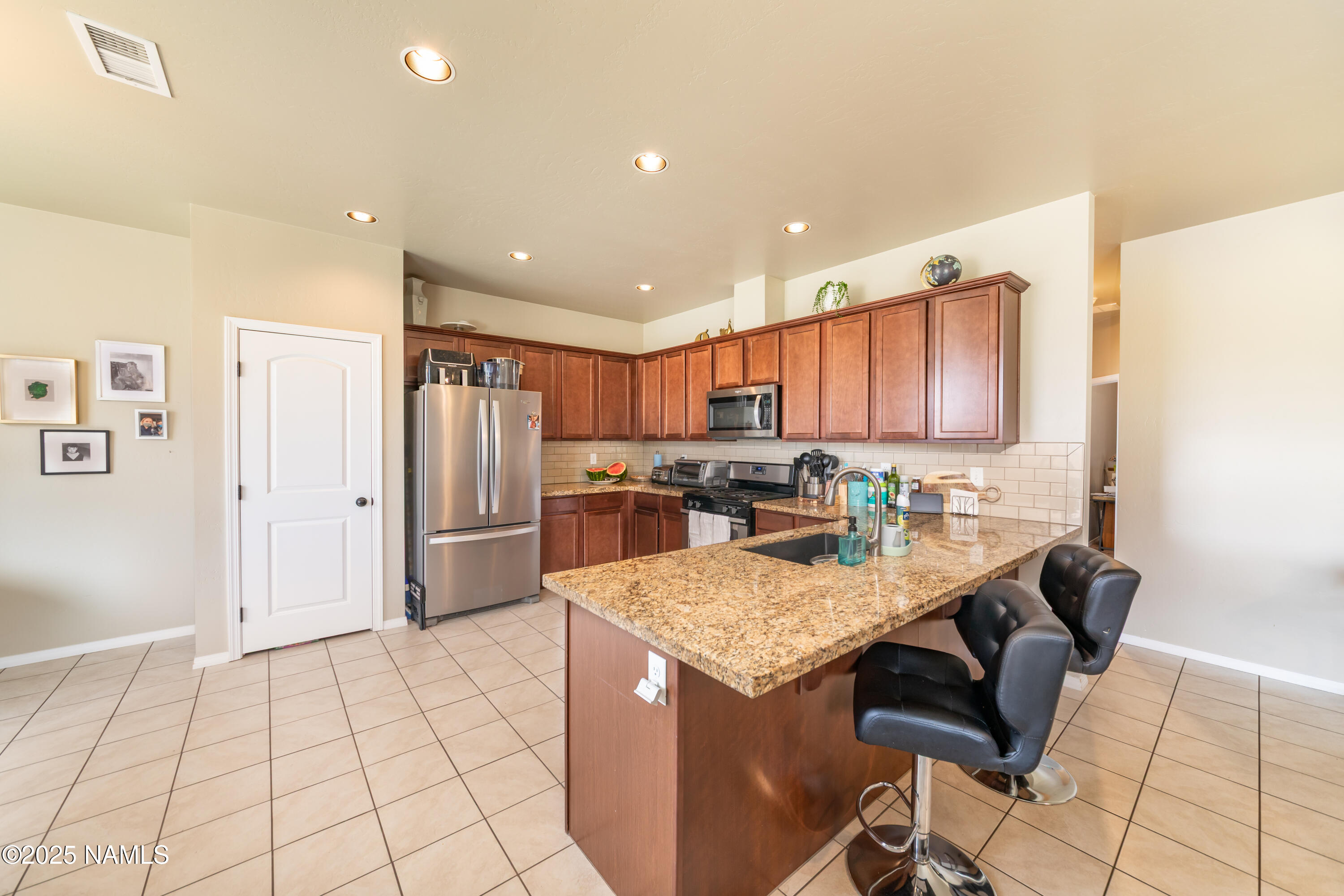 4500 Centaurus Road Bellemont, AZ 86015 - Photo 8 of 20 a kitchen with granite countertop a refrigerator a stove and white cabinets with wooden floor