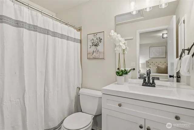 a bathroom with a granite countertop sink a toilet and a mirror