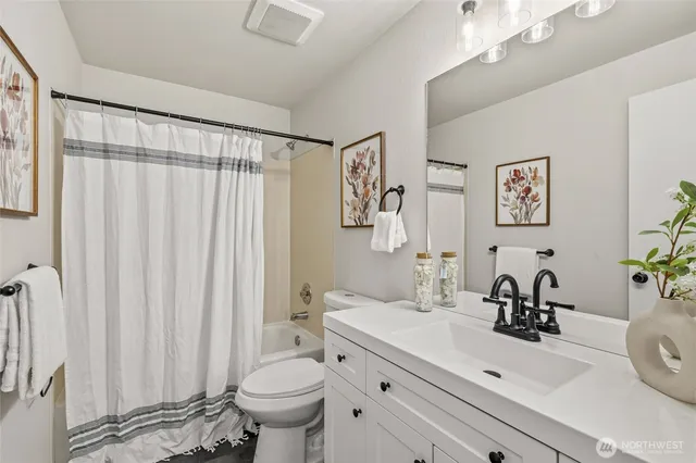 a bathroom with a sink a toilet and a large mirror