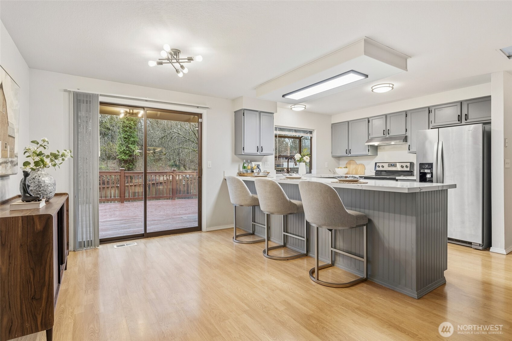 23506 13th Place West Bothell, WA 98021 - Photo 6 of 26 a kitchen with stainless steel appliances a refrigerator a sink dishwasher a dining table and chairs with wooden floor