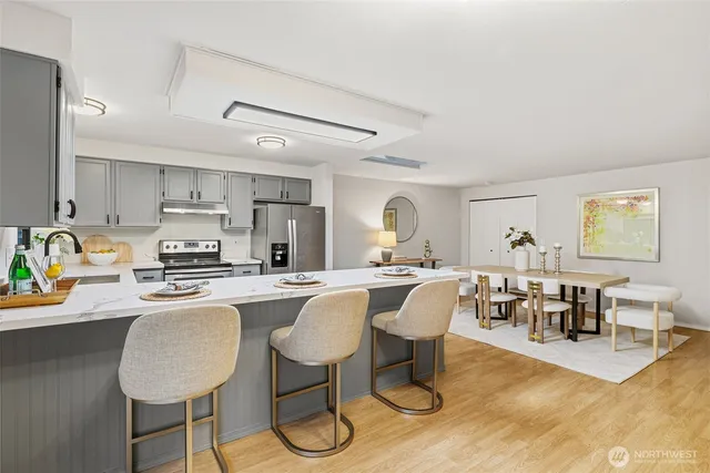 a kitchen with a dining table chairs cabinets and stainless steel appliances