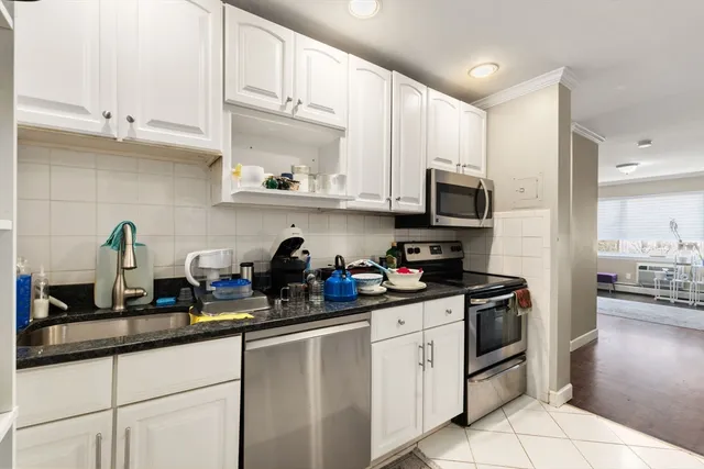 a kitchen with granite countertop a sink a stove and cabinets