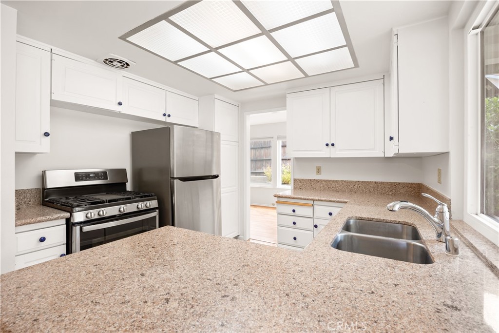 3430 Bahia Place Riverside, CA 92507 - Photo 17 of 34 a kitchen with granite countertop a sink stainless steel appliances and cabinets