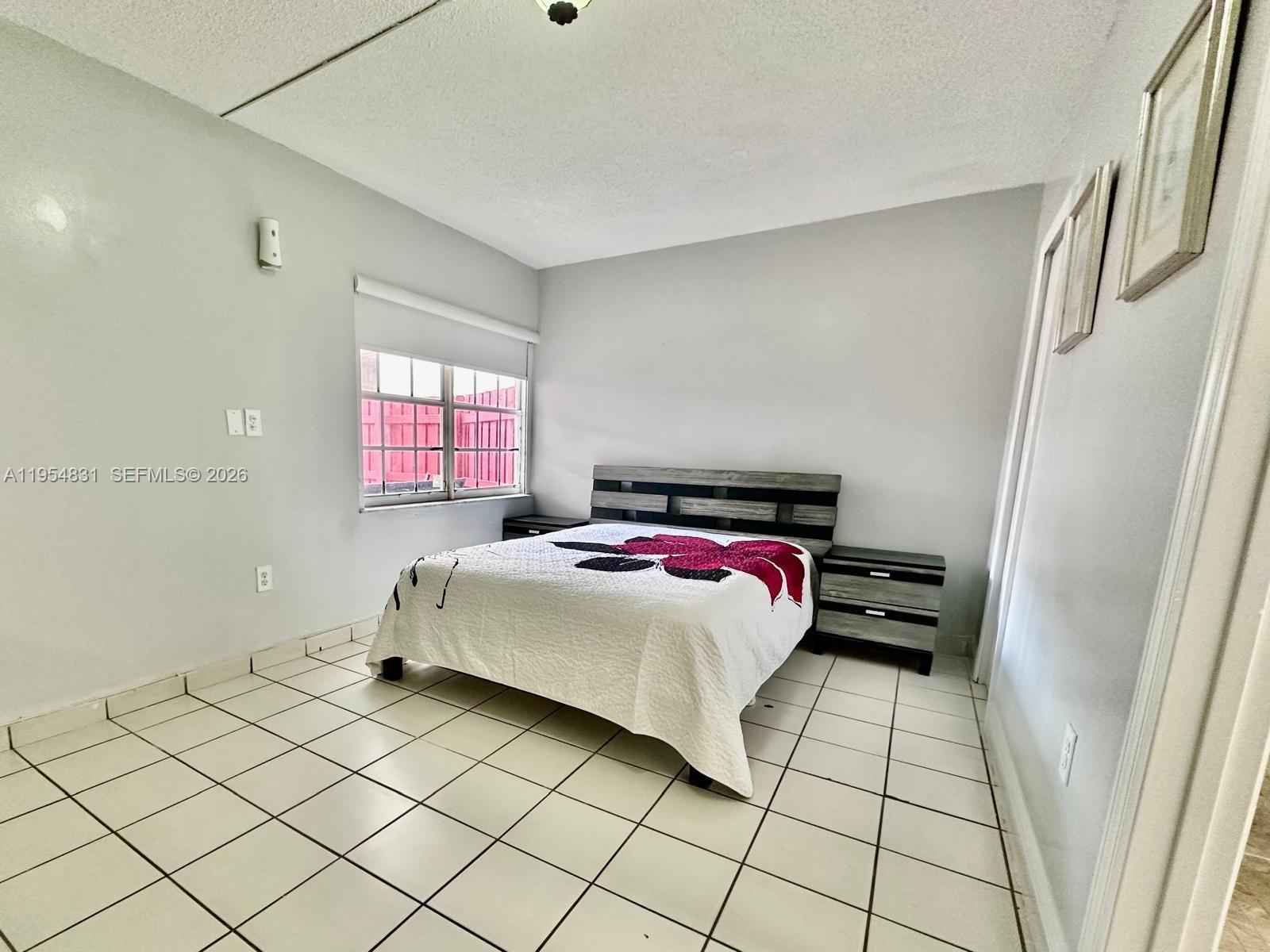 15645 Southwest 82nd Cir Lane, Unit 75 Miami, FL 33193 - Photo 19 of 20 a bedroom with a bed and a window