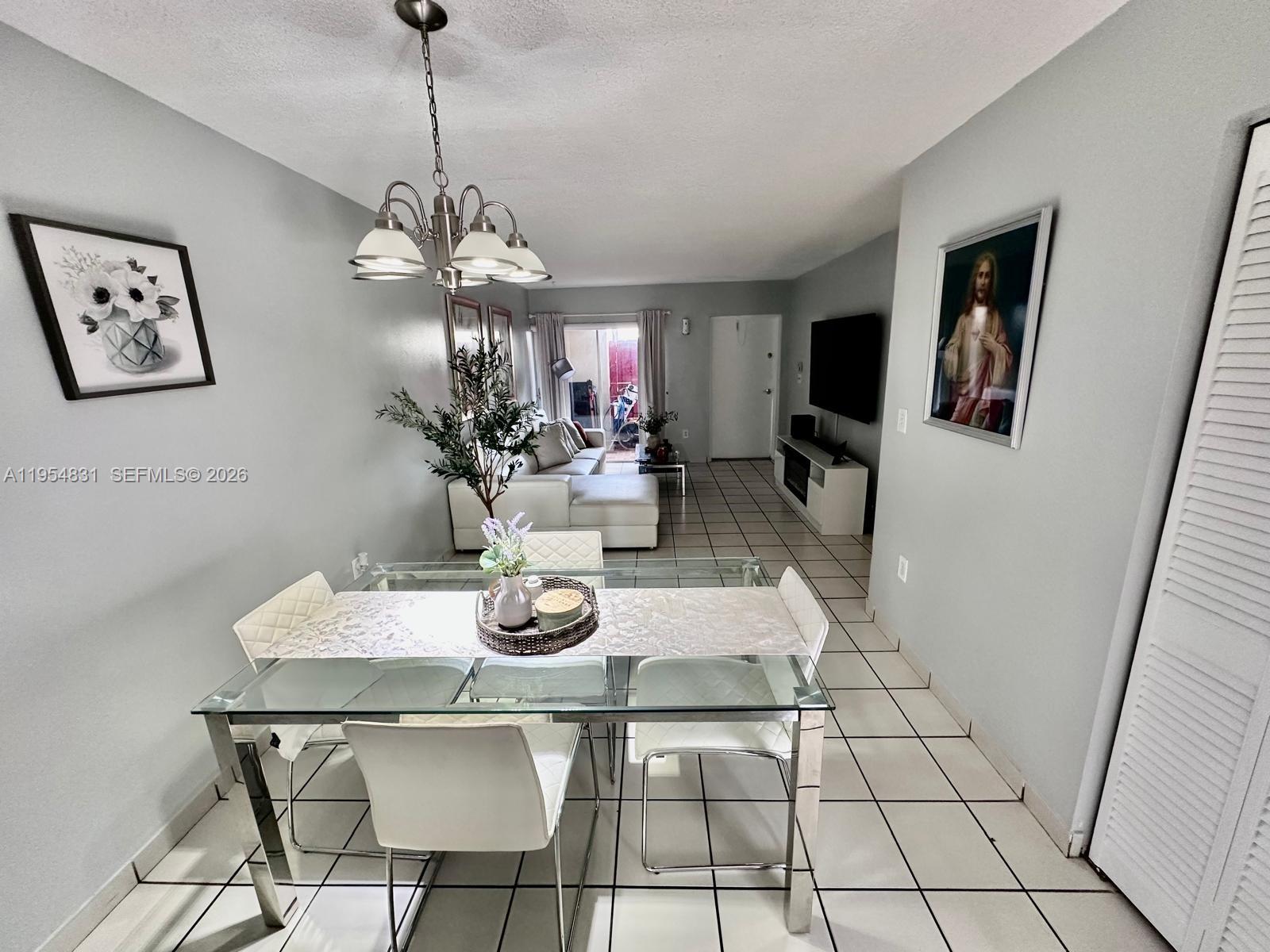 15645 Southwest 82nd Cir Lane, Unit 75 Miami, FL 33193 - Photo 8 of 20 a view of a dining room with furniture wooden floor and chandelier