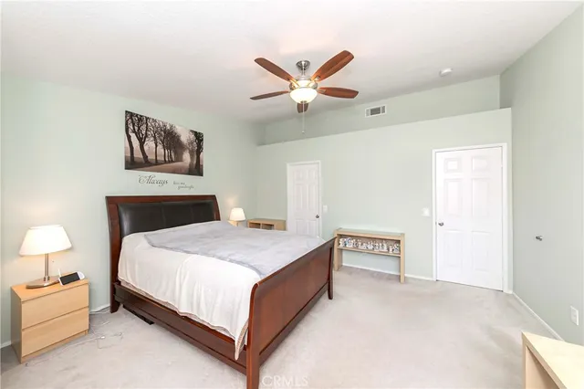 a spacious bedroom with a bed and a ceiling fan