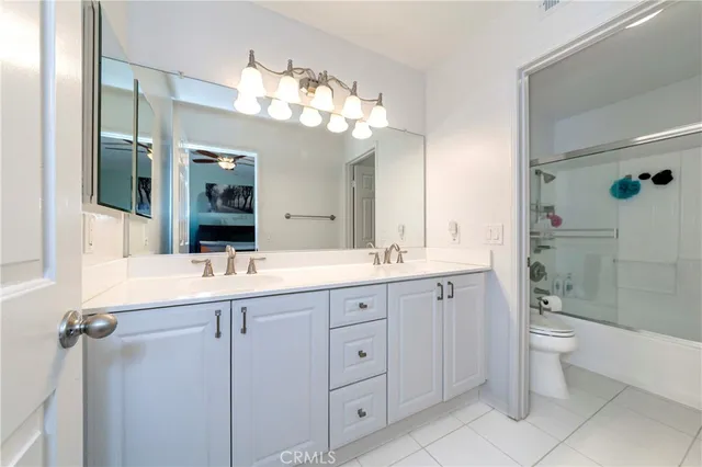 a bathroom with a double vanity sink mirror and toilet