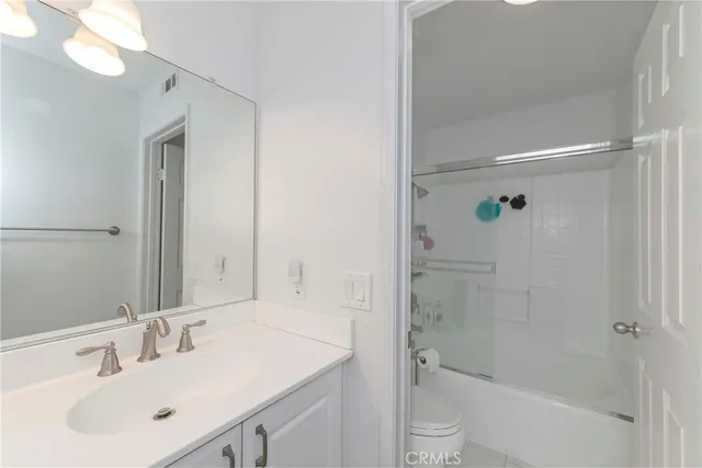 a bathroom with a bathtub shower sink vanity and toilet