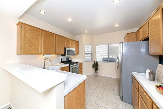 a kitchen with stainless steel appliances granite countertop a sink a stove and a refrigerator