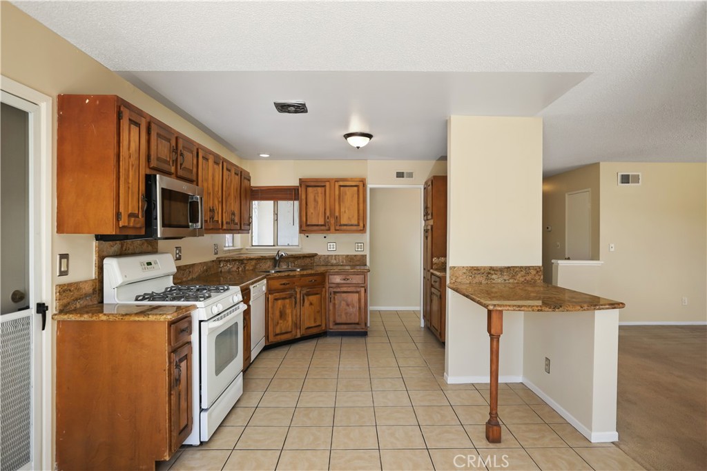15902 King Circle Westminster, CA 92683 - Photo 14 of 43 a kitchen with stainless steel appliances granite countertop a stove top oven a sink dishwasher and a refrigerator