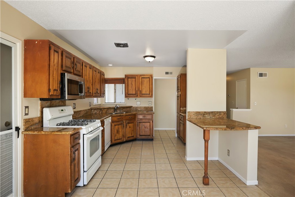 15902 King Circle Westminster, CA 92683 - Photo 15 of 43 a kitchen with stainless steel appliances granite countertop a stove top oven a sink dishwasher and a refrigerator