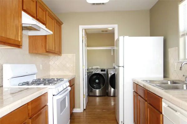 a kitchen with a refrigerator and a stove top oven