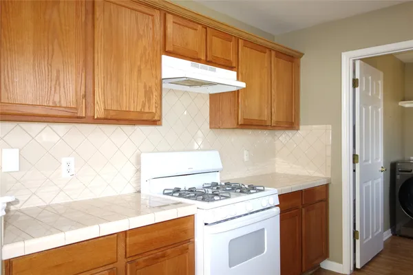 a kitchen with granite countertop cabinets stainless steel appliances and a counter space