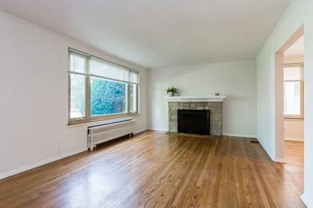 wooden floor fireplace and windows in an empty room