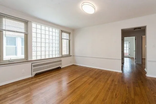 wooden floor in an empty room with a window
