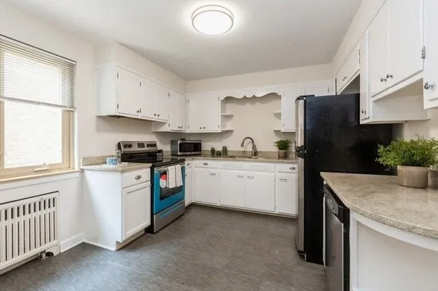 a kitchen with granite countertop white cabinets and white appliances