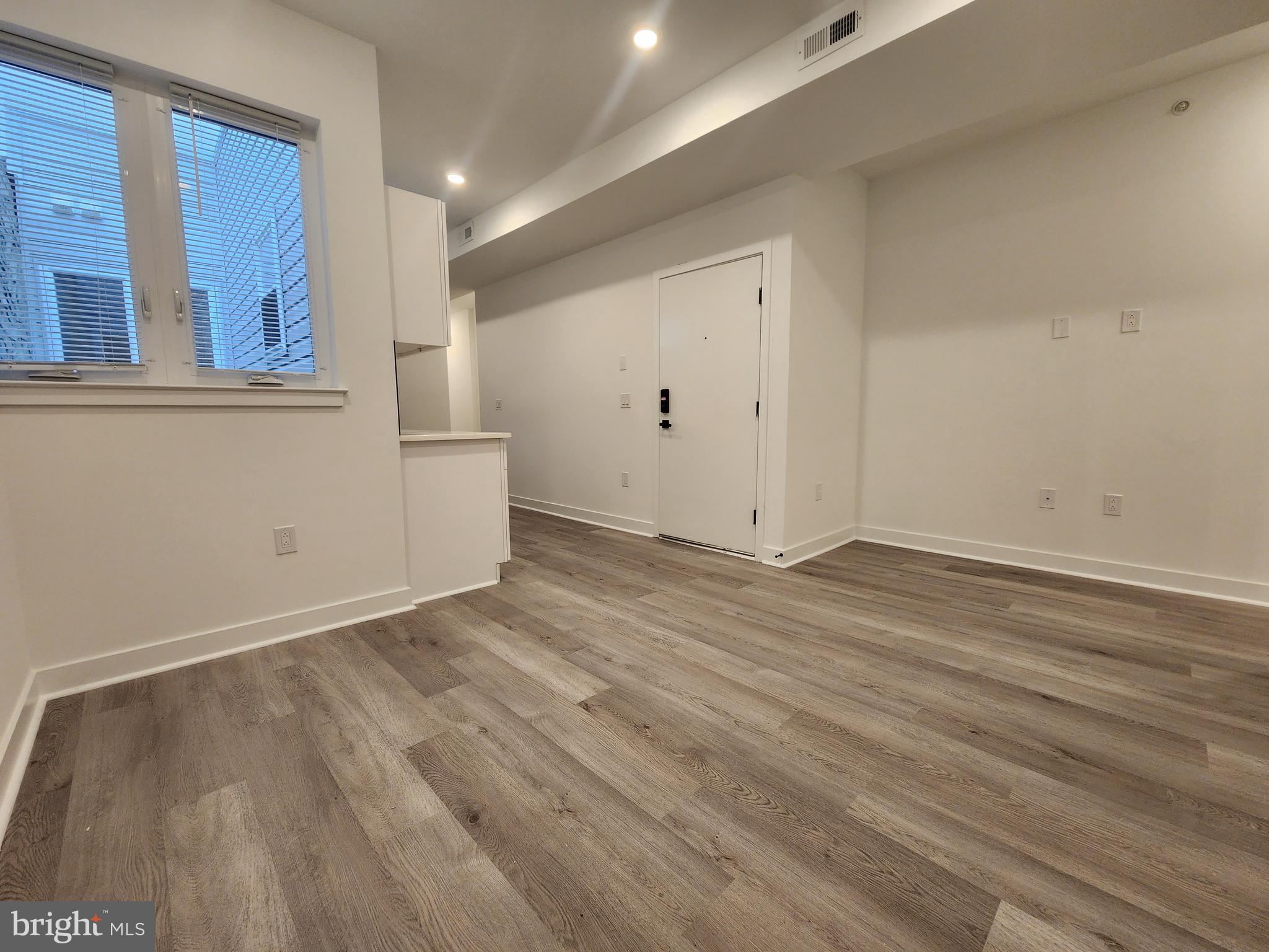 1838 North 17th Street, Unit 3 Philadelphia, PA 19121 - Photo 4 of 14 an empty room with wooden floor and windows