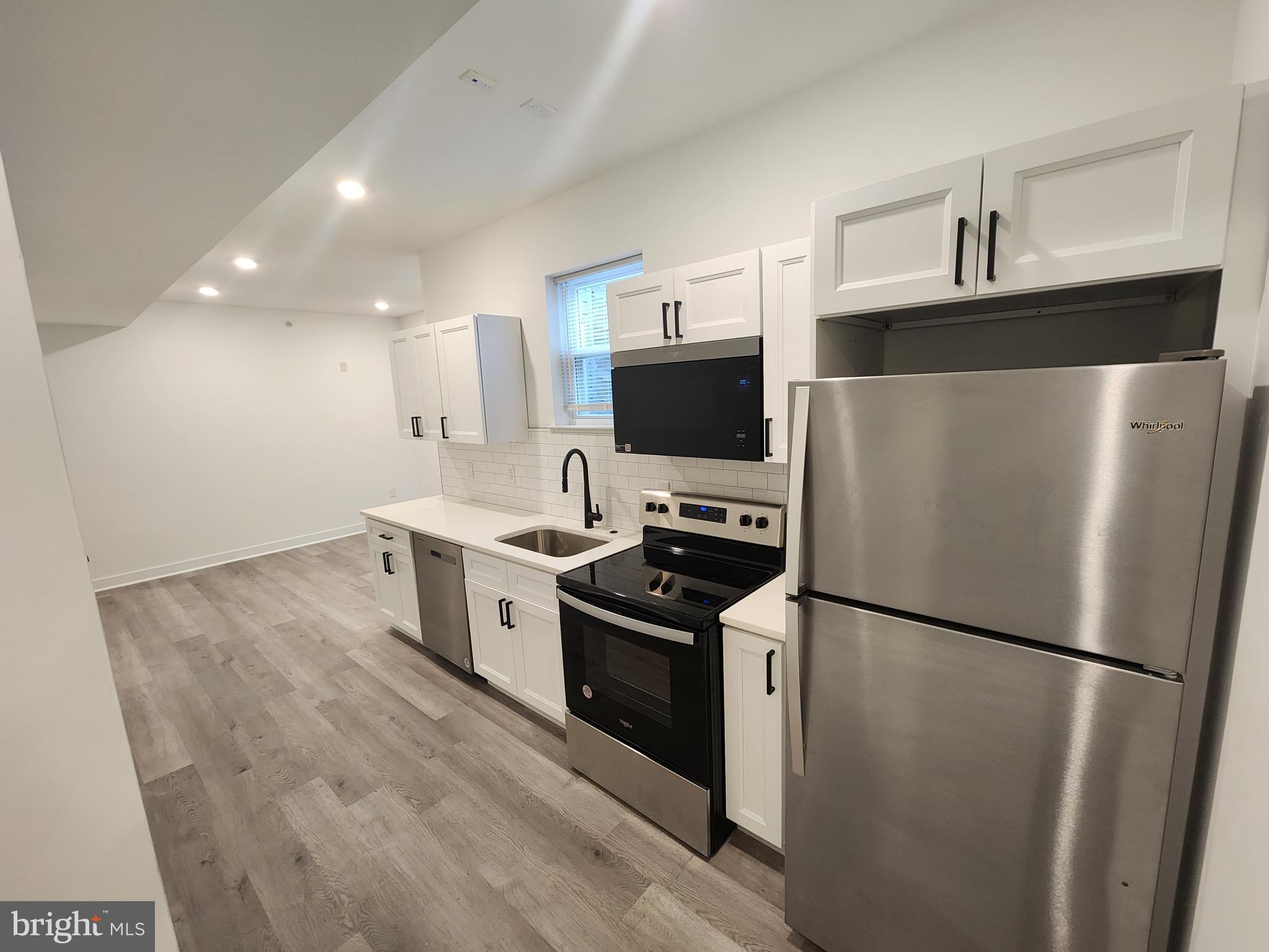 1838 North 17th Street, Unit 3 Philadelphia, PA 19121 - Photo 5 of 14 a kitchen with a refrigerator a stove top oven a sink and cabinets