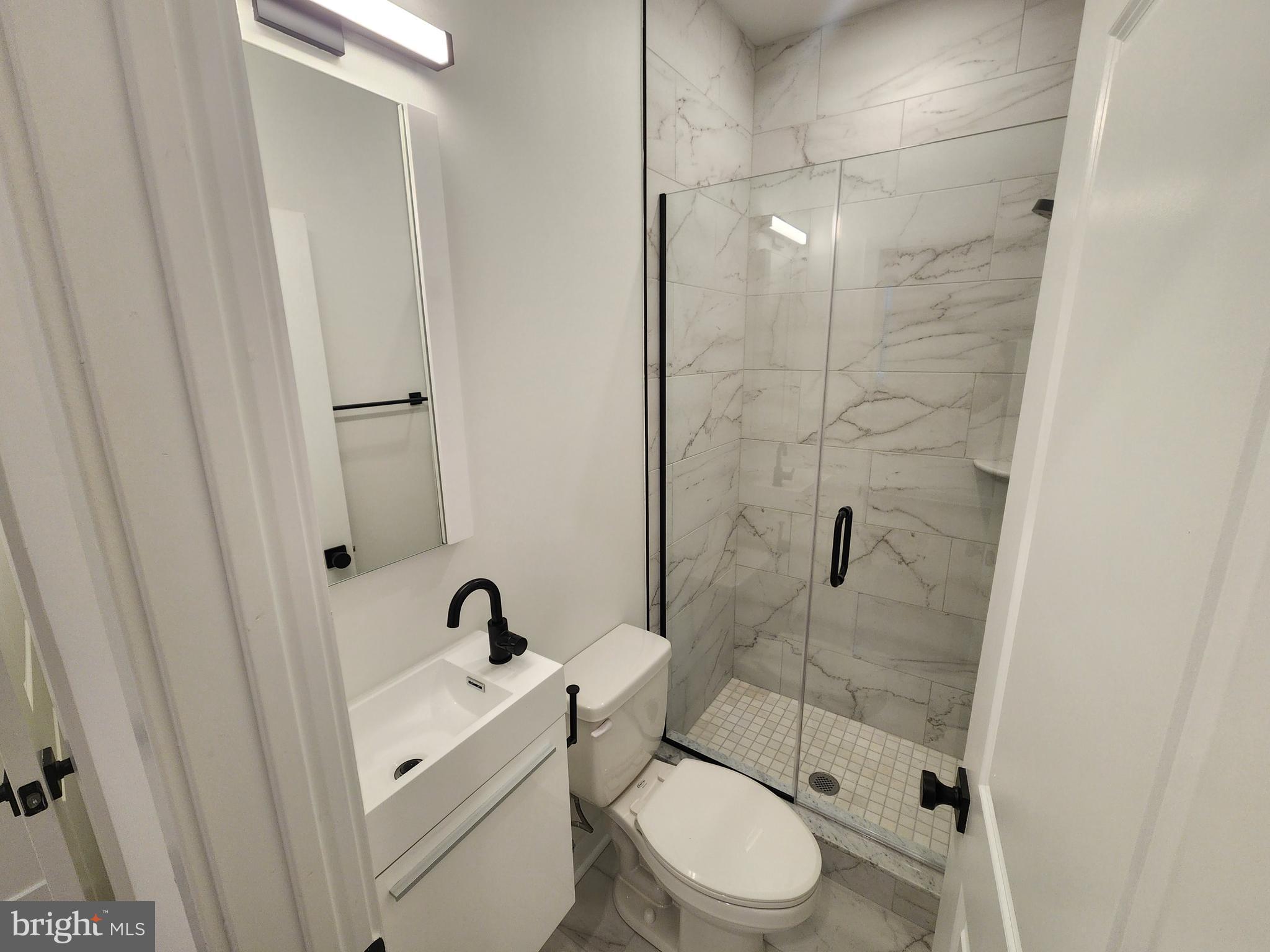 1838 North 17th Street, Unit 3 Philadelphia, PA 19121 - Photo 7 of 14 a bathroom with a toilet sink a mirror and shower