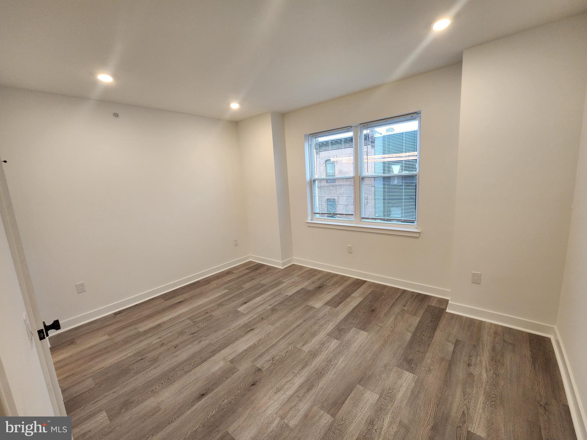 1838 North 17th Street, Unit 3 Philadelphia, PA 19121 - Photo 10 of 14 an empty room with wooden floor and windows